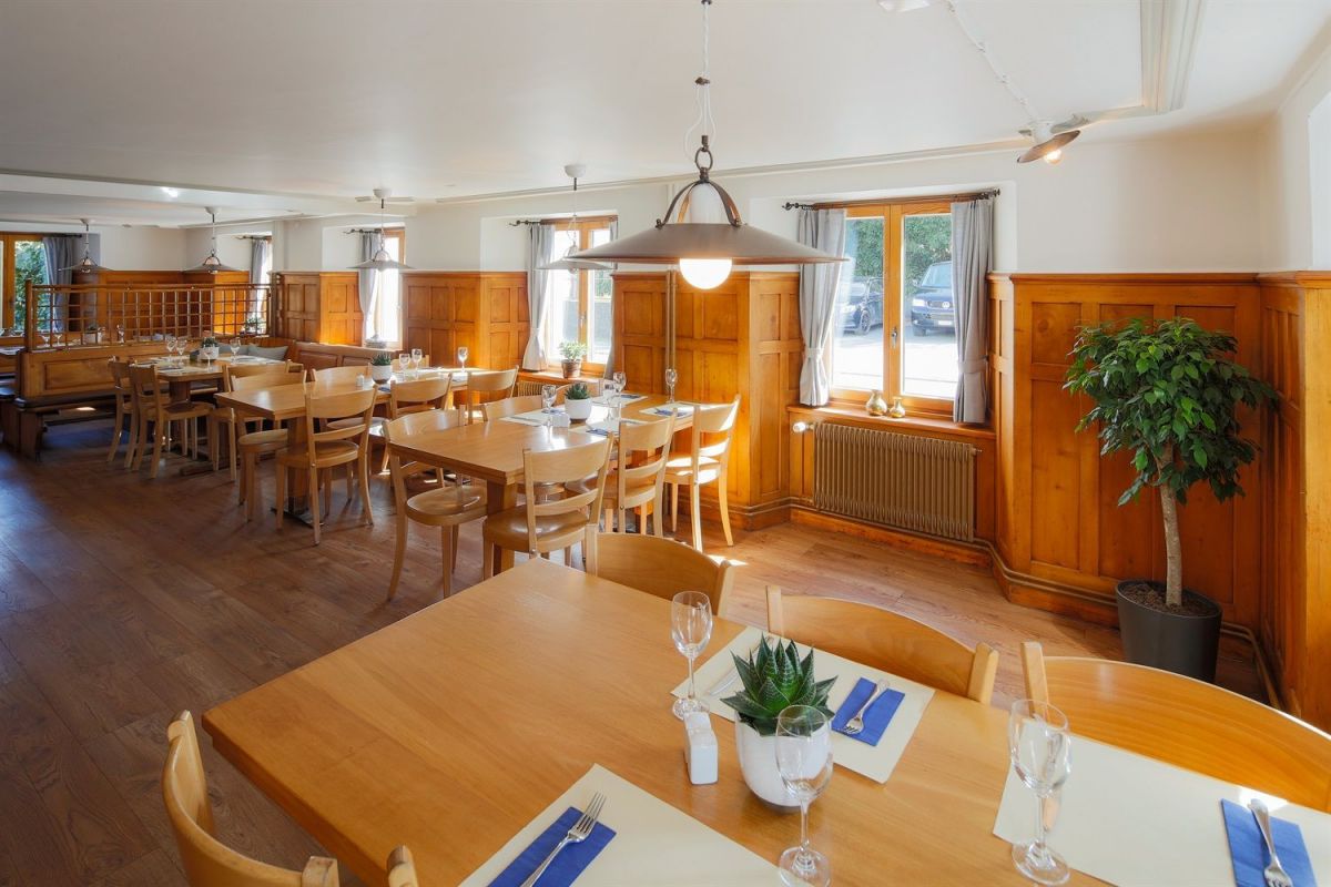 Helle Gaststube im Restaurant Rössle Schaan mit Holzvertäfelung und gedeckten Tischen